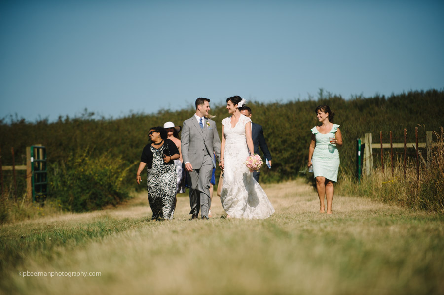 Bride and Groom walk through meadow